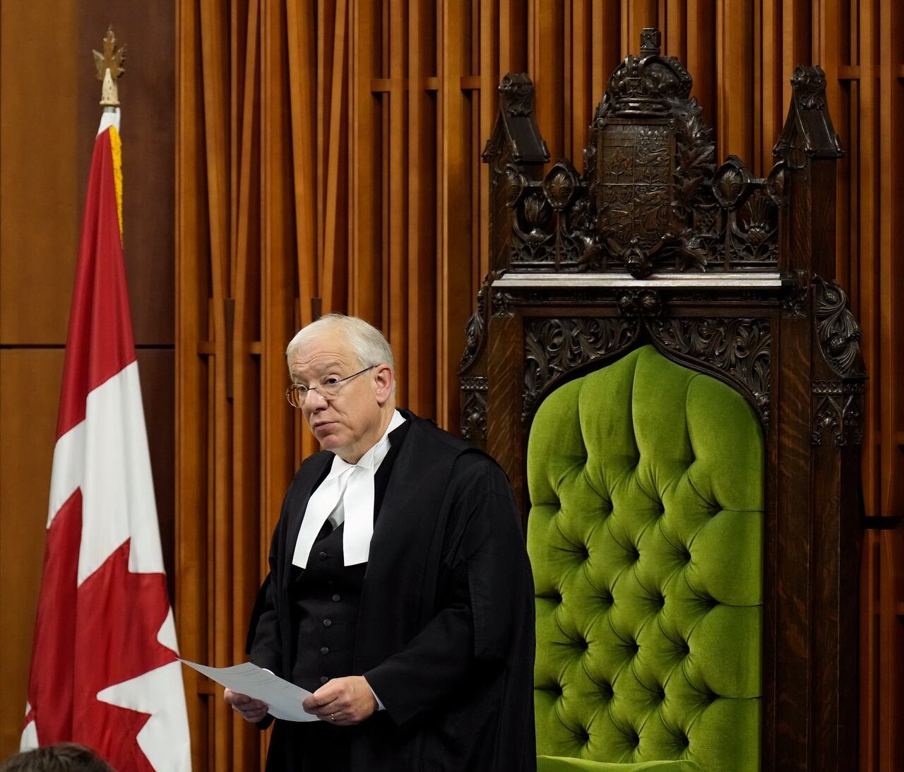 default-229 A man in ceremonial robes stands in a legislative building.